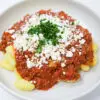 Mediterranean-Inspired Ground Lamb Ragu served over gnocchi pasta, topped with crumbled goat cheese and fresh parsley.